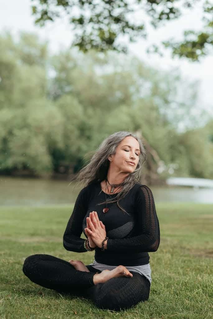 Reflective woman meditating in Lotus pose with namaste hands